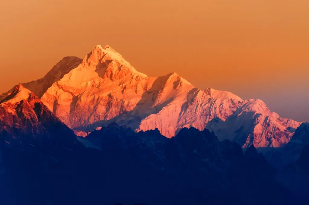 Prachtig eerste licht van zonsopgang op de berg Kanchenjugha, Himalaya-gebergte, Sikkim, India. Oranje tint op de bergen bij zonsopgang.